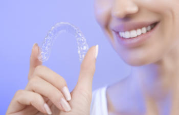 woman holding her invisalign braces