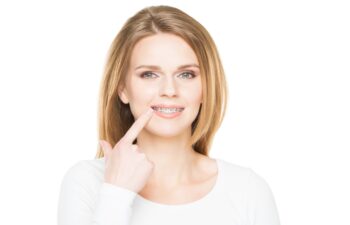 Attractive teenage girl smiling in dental braces. Stomatology concept.