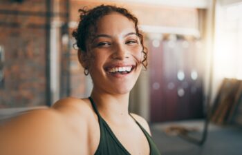 Fitness portrait, exercise and gym selfie of a woman happy about workout, training motivation and body wellness. Young sports female or athlete with a smile on social media blog for healthy lifestyle.